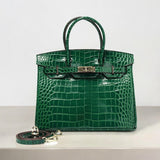 Emerald green crocodile-embossed leather handbag with gold hardware and detachable strap