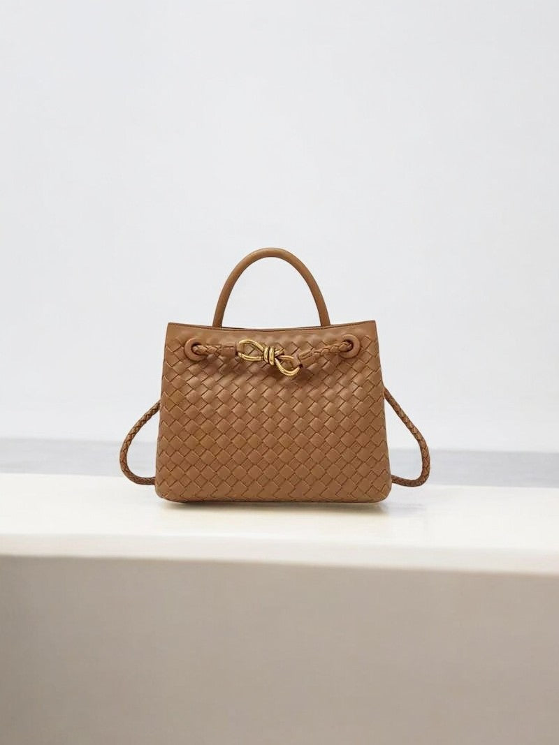 Tan woven leather handbag with gold knot clasp and top handle